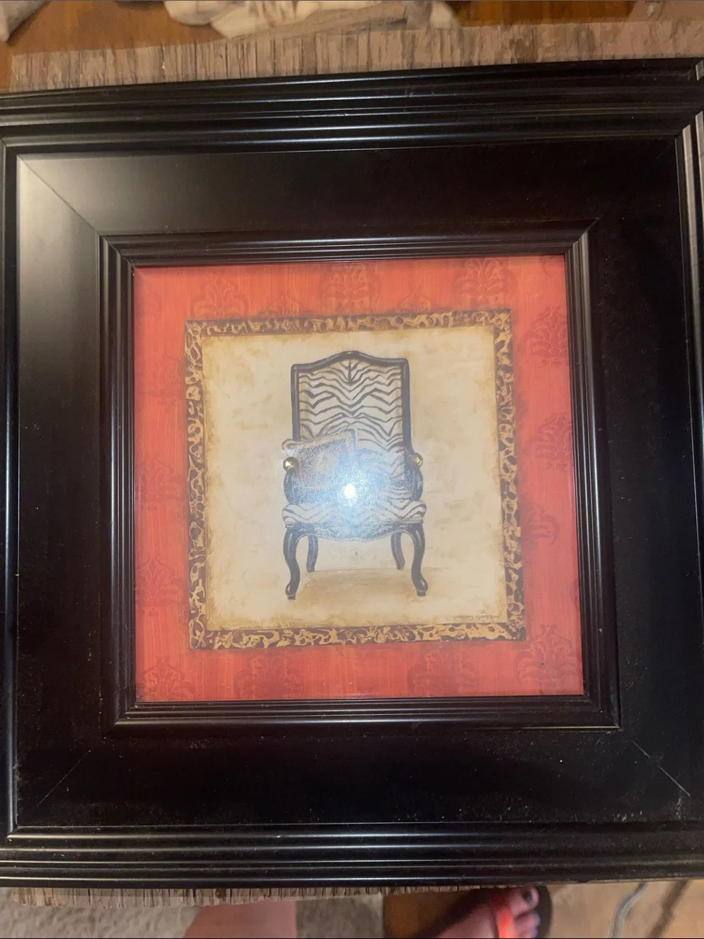 Black Framed Wall Art with Red Accent and Zebra-Pattern Chair